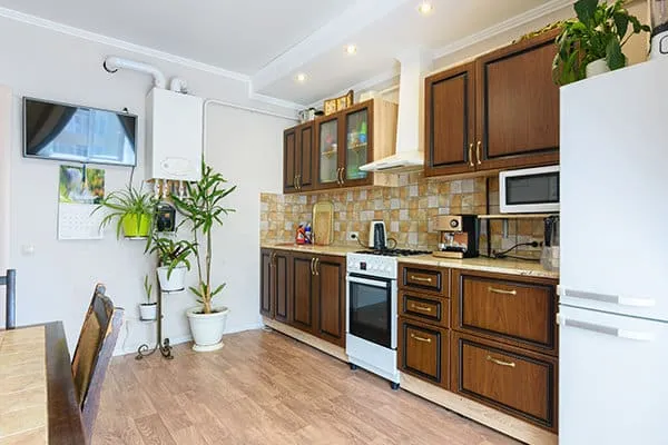 Before: a dated kitchen with brown cabinets and a tile backsplash